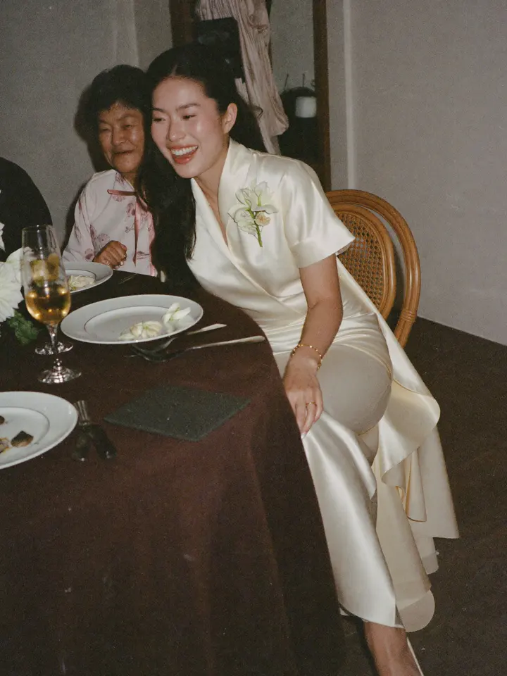 A bride laughing with her grandmother at a lunch table